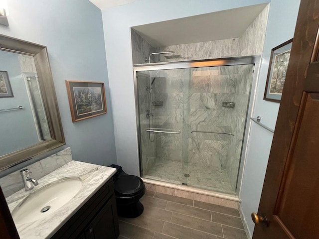 bathroom with vanity, toilet, and a shower with shower door