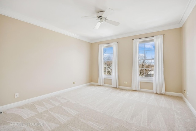 spare room featuring a ceiling fan, light carpet, crown molding, and baseboards