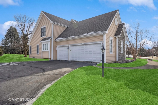 view of home's exterior featuring an attached garage, a yard, aphalt driveway, and a shingled roof