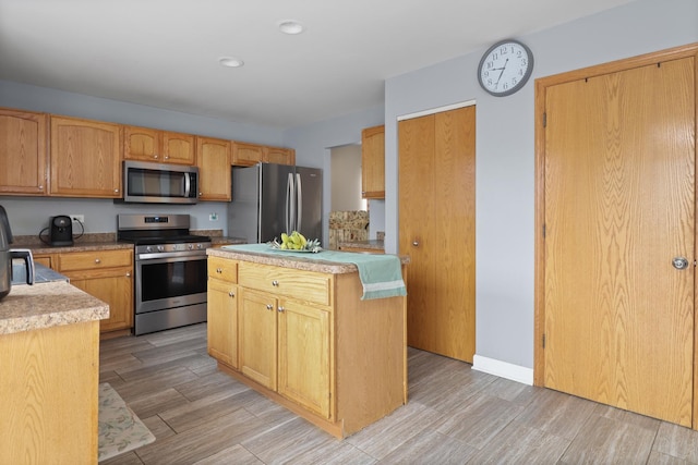 1711 Fallbrook Dr, Hampshire, IL 60140 - kitchen featuring stainless steel appliances, light countertops, light wood-style floors, a kitchen island, and recessed lighting