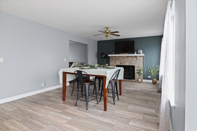 1711 Fallbrook Dr, Hampshire, IL 60140 - dining space with a fireplace, a ceiling fan, baseboards, and light wood-style floors