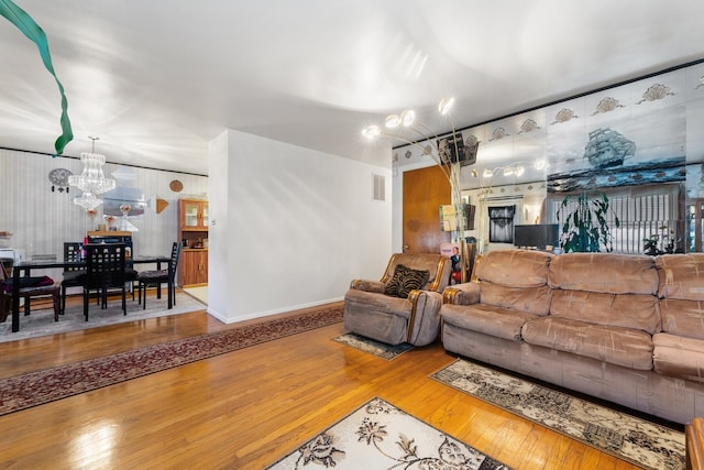 living room with hardwood / wood-style flooring and a notable chandelier