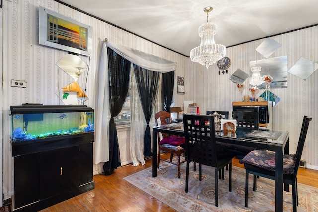 dining area featuring hardwood / wood-style floors and an inviting chandelier