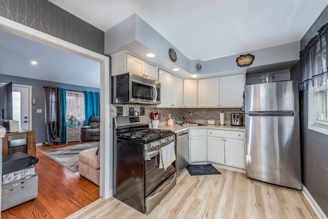 kitchen featuring white cabinetry, sink, backsplash, and appliances with stainless steel finishes