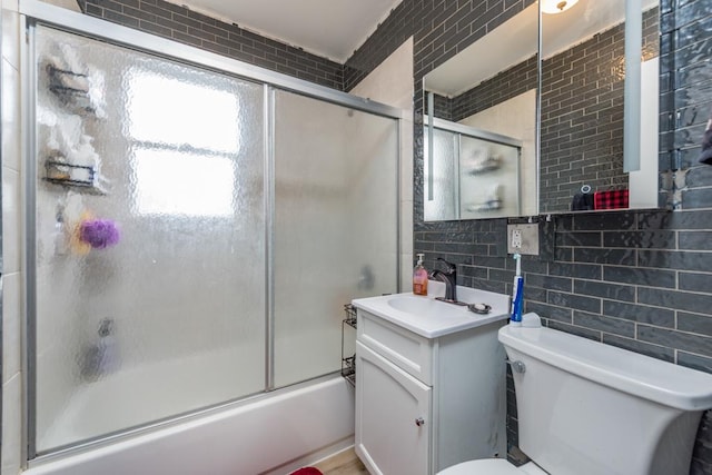 full bathroom with toilet, combined bath / shower with glass door, tasteful backsplash, tile walls, and vanity