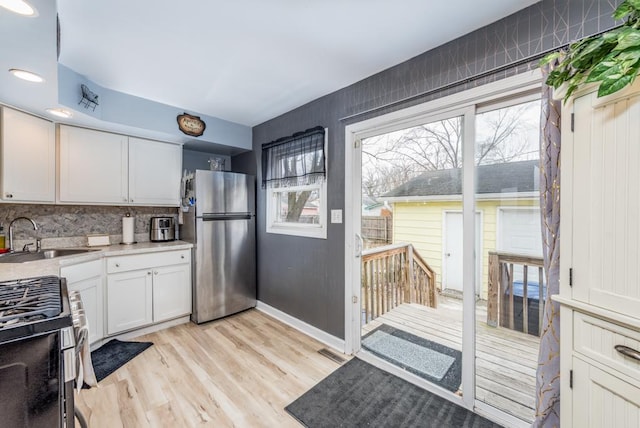 kitchen featuring white cabinetry, stainless steel appliances, sink, and a wealth of natural light