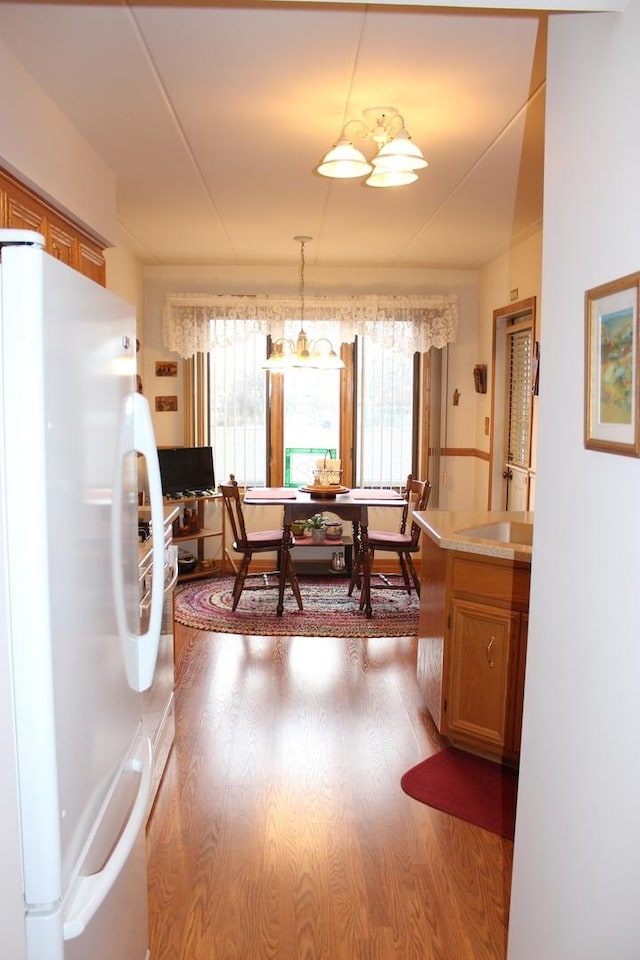 dining area with light hardwood / wood-style floors and a chandelier