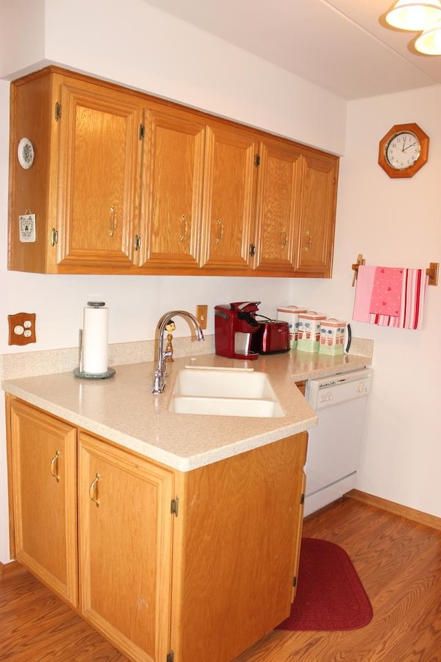 kitchen with sink, white dishwasher, and light hardwood / wood-style flooring