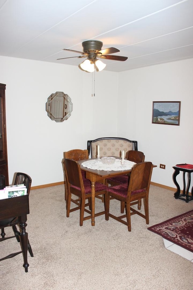 dining area featuring light carpet and ceiling fan