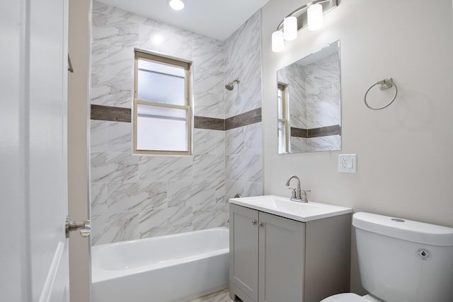 full bathroom featuring tiled shower / bath, vanity, and toilet