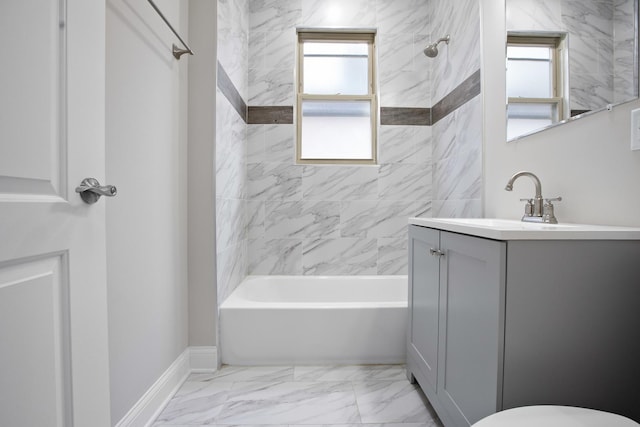 bathroom with a healthy amount of sunlight, tiled shower / bath combo, and vanity