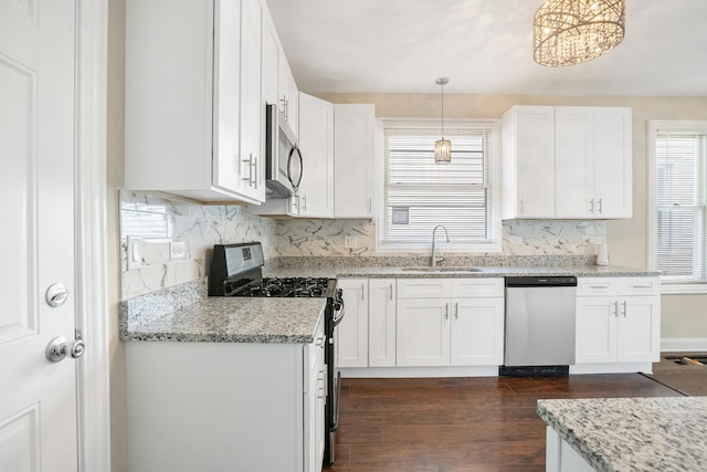 kitchen with white cabinetry, hanging light fixtures, sink, and appliances with stainless steel finishes