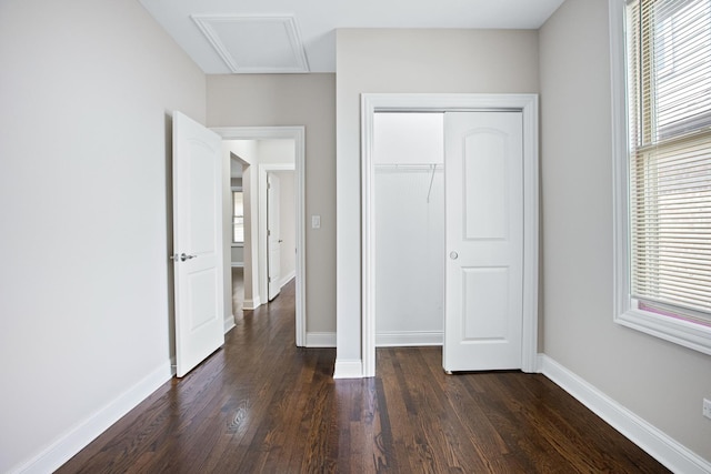 unfurnished bedroom featuring dark wood-type flooring and a closet