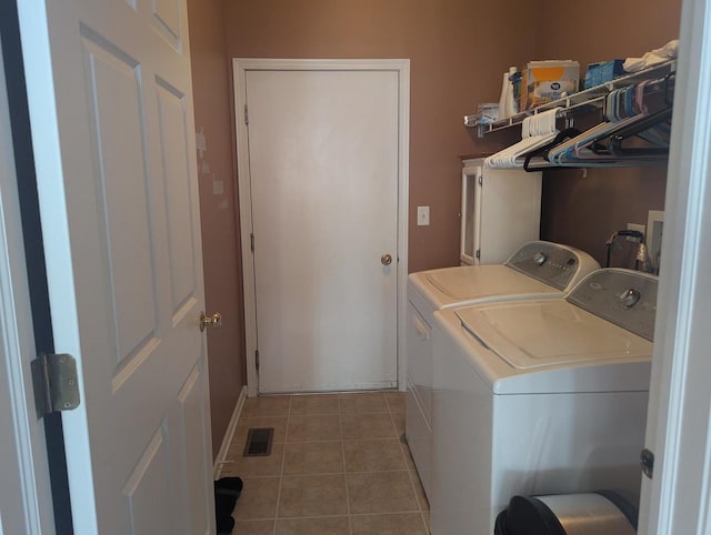 clothes washing area featuring washing machine and clothes dryer and tile patterned floors