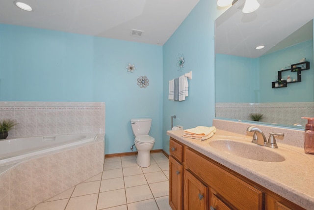 bathroom with a relaxing tiled tub, tile patterned floors, toilet, and vanity