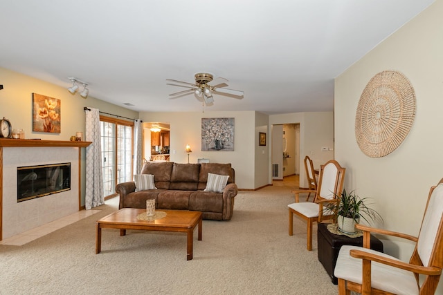 carpeted living room with ceiling fan and a fireplace