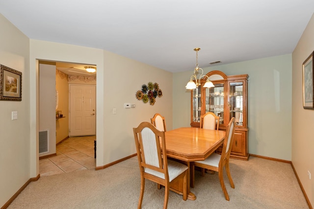 carpeted dining area featuring an inviting chandelier