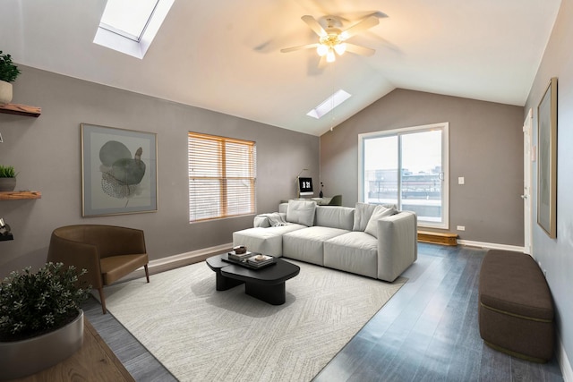 living room featuring lofted ceiling with skylight, plenty of natural light, baseboards, and dark wood-type flooring