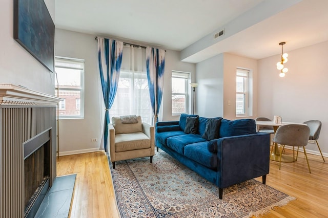 living room featuring a healthy amount of sunlight, light wood-style flooring, and visible vents