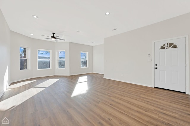 unfurnished living room featuring ceiling fan and light wood-type flooring