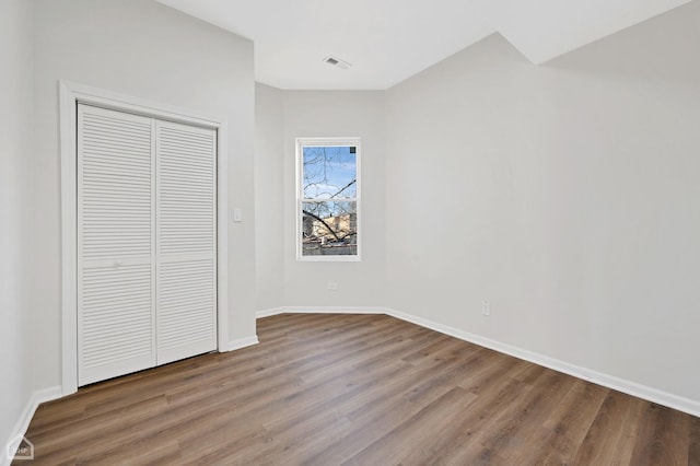 unfurnished bedroom featuring hardwood / wood-style flooring and a closet