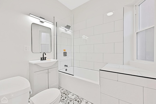 full bathroom featuring vanity, tiled shower / bath, and toilet