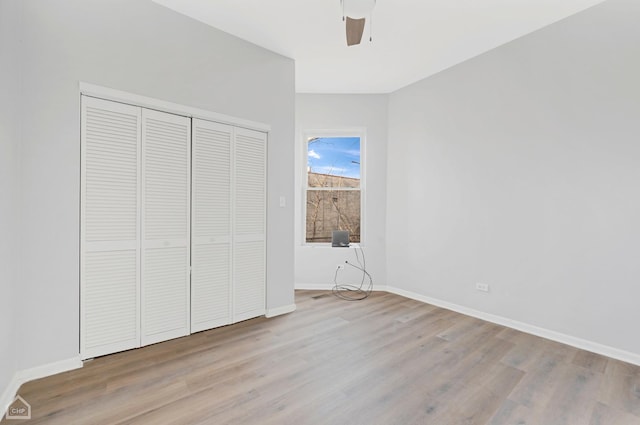 unfurnished bedroom featuring ceiling fan, light wood-type flooring, and a closet