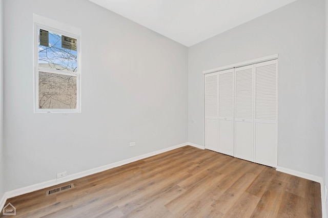 unfurnished bedroom featuring hardwood / wood-style floors and a closet