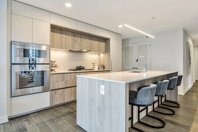 211 N Harbor Dr Unit 1909, Chicago, IL 60601 - kitchen featuring sink, gas stovetop, a center island with sink, dark hardwood / wood-style floors, and stainless steel double oven