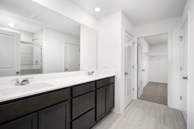 bathroom featuring vanity and a shower with shower door