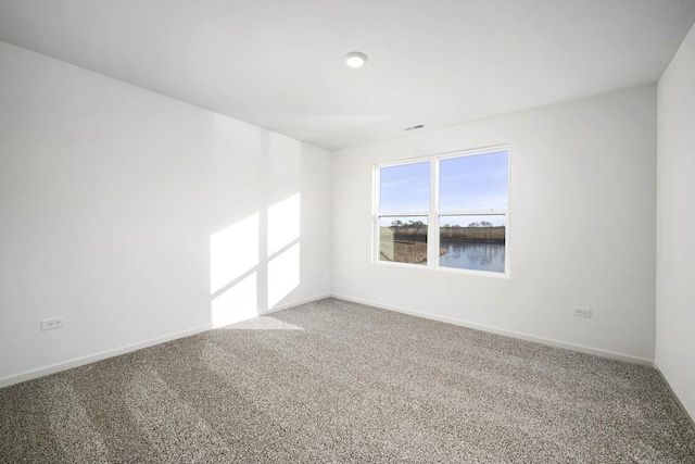 carpeted spare room featuring a water view