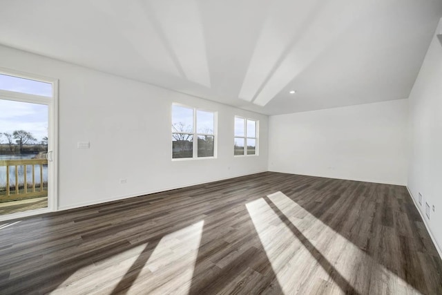 unfurnished room featuring a water view and dark wood-type flooring