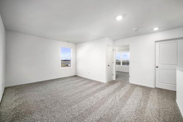 spare room featuring carpet and a wealth of natural light