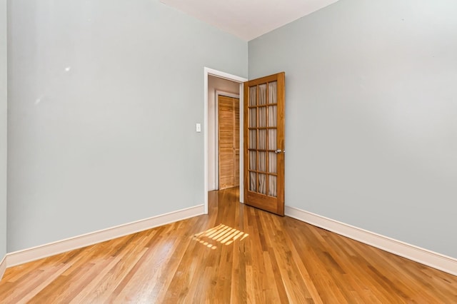 unfurnished room with baseboards and wood finished floors