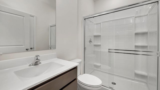 bathroom featuring walk in shower, vanity, and toilet