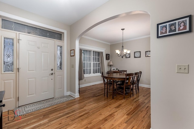 foyer featuring crown molding, hardwood / wood-style flooring, and a chandelier