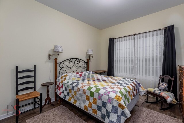 bedroom with dark hardwood / wood-style floors