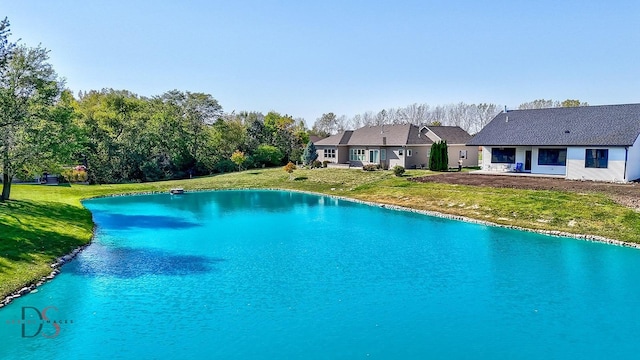 view of pool featuring a lawn and a water view