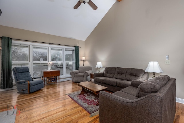 living room with hardwood / wood-style flooring, ceiling fan, and high vaulted ceiling