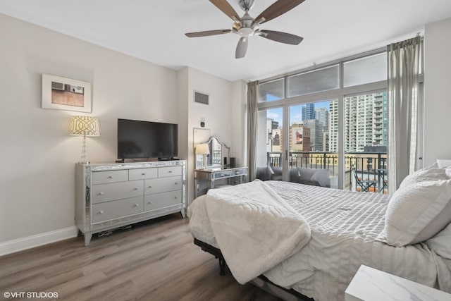 bedroom featuring ceiling fan, access to exterior, hardwood / wood-style floors, and a wall of windows