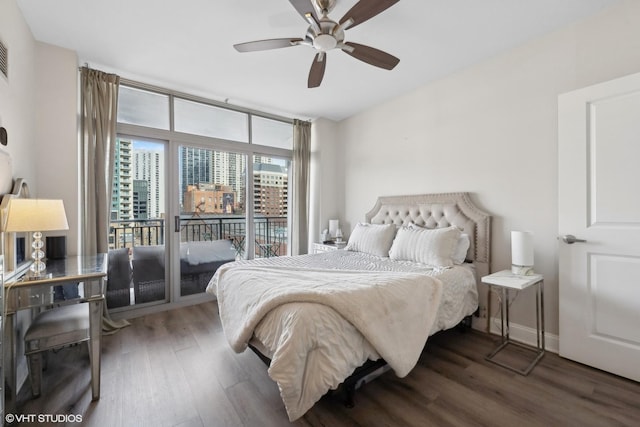 bedroom featuring dark wood-type flooring, access to outside, ceiling fan, and a wall of windows