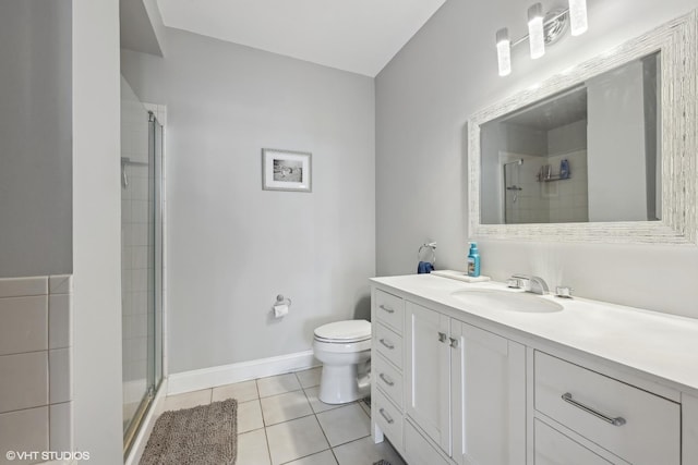 bathroom with tile patterned flooring, vanity, toilet, and walk in shower