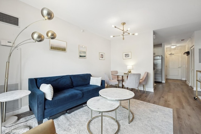 living room featuring an inviting chandelier and hardwood / wood-style flooring