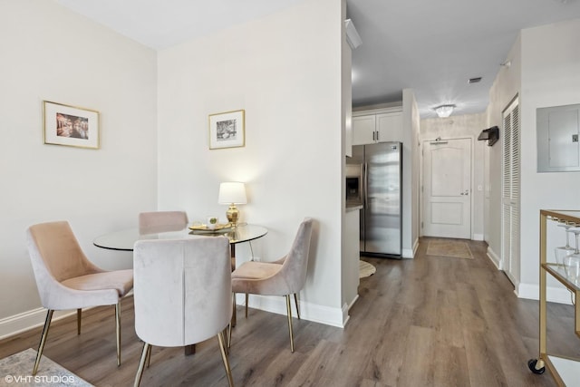 dining area featuring hardwood / wood-style floors and electric panel