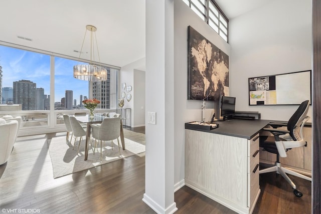 home office featuring a notable chandelier, dark hardwood / wood-style floors, and expansive windows