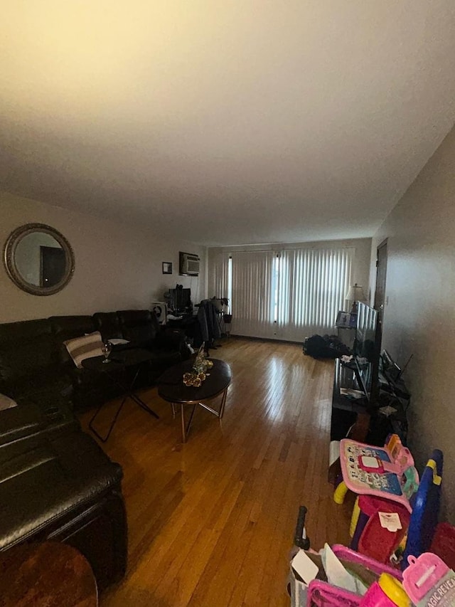 living room featuring hardwood / wood-style flooring and a wall mounted AC