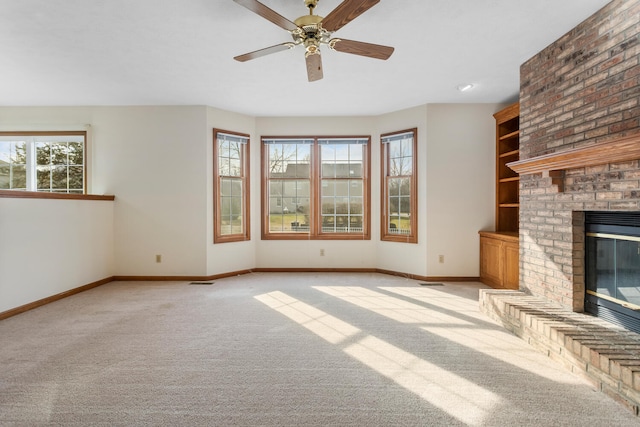 unfurnished living room featuring light carpet, ceiling fan, a fireplace, and baseboards