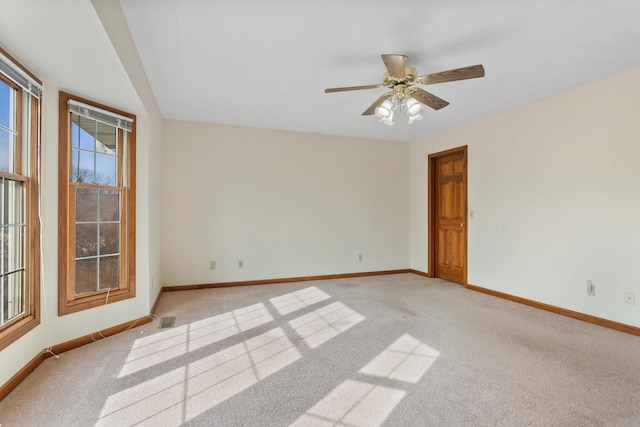 empty room featuring light colored carpet, visible vents, and baseboards