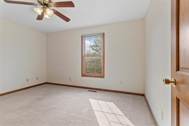 spare room with baseboards, ceiling fan, visible vents, and light colored carpet