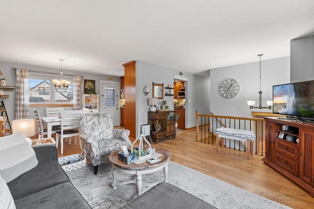 living room with a notable chandelier and light hardwood / wood-style flooring